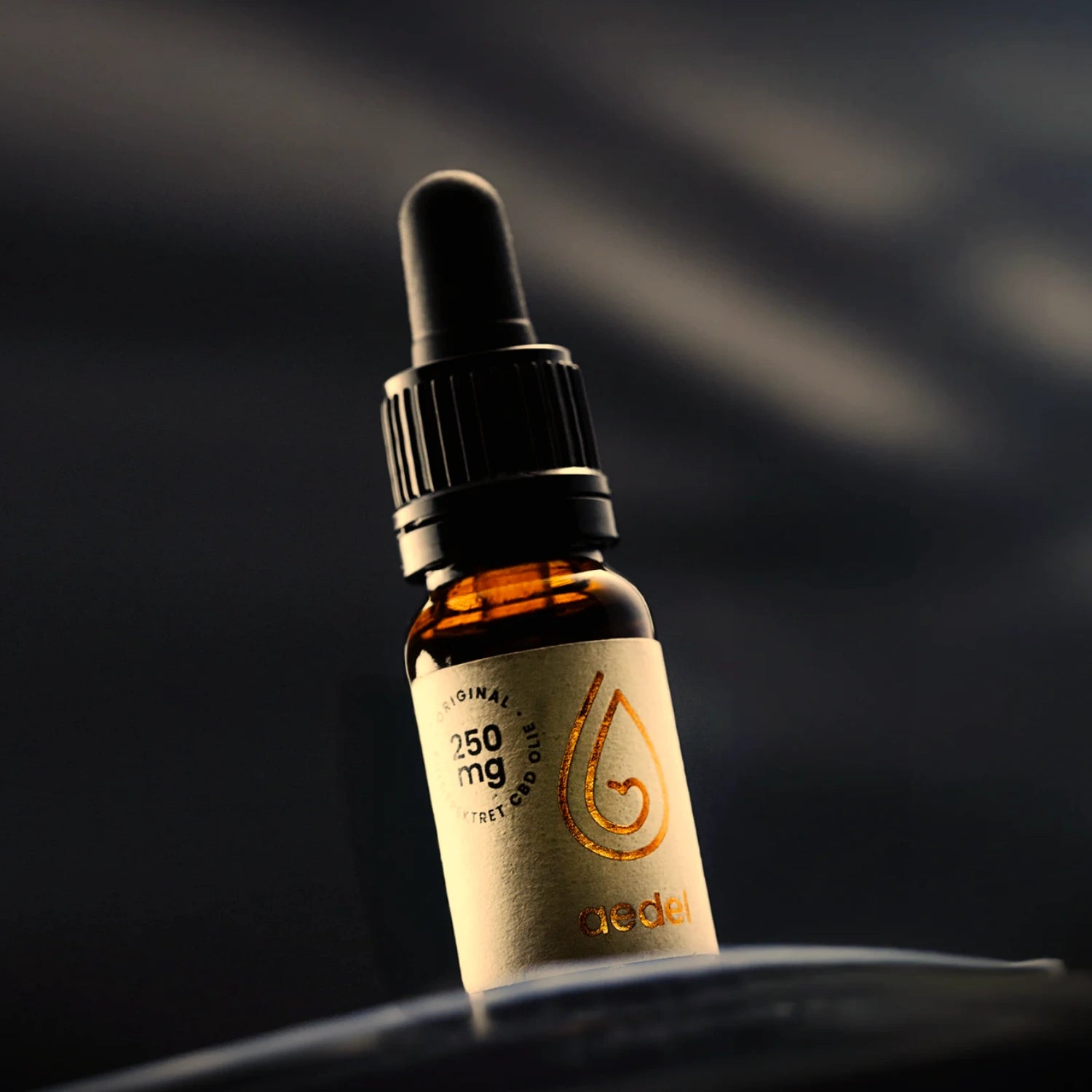 Nærbillede af Aedel 250 mg CBD-olieflaske med pipette mod mørk baggrund – fremhæver luksuriøs, solventfri fuldspektrum kvalitet.