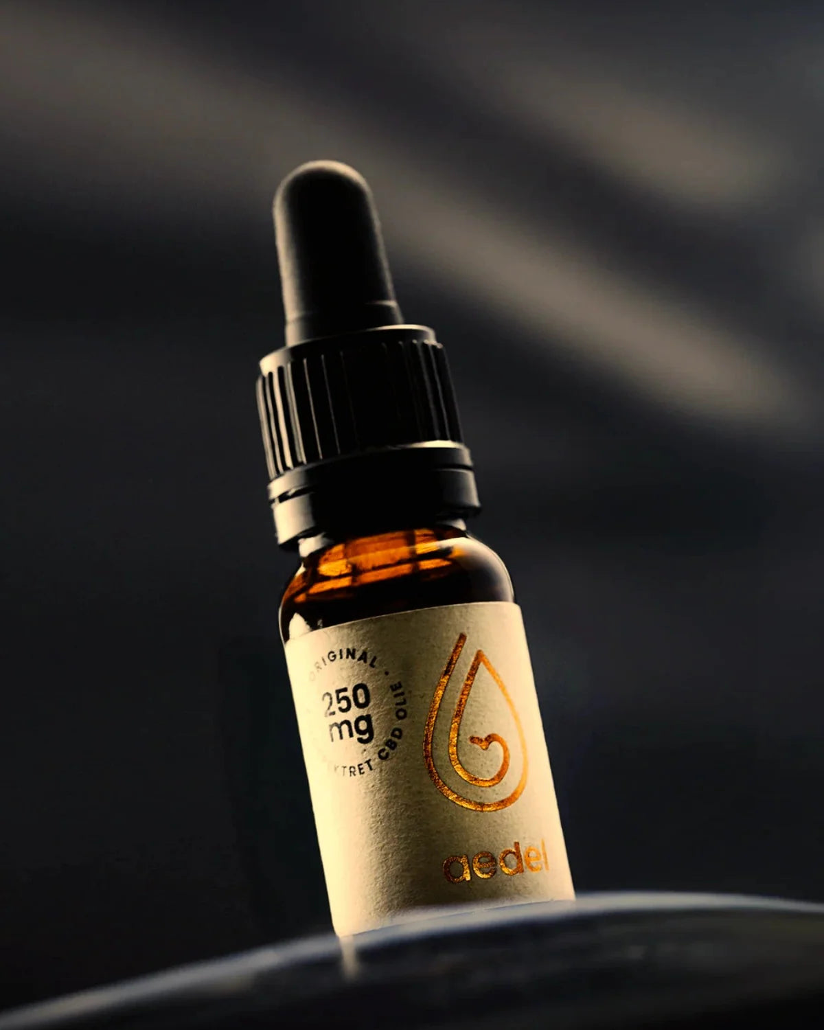 Nærbillede af Aedel 250 mg CBD-olieflaske med pipette mod mørk baggrund – fremhæver luksuriøs, solventfri fuldspektrum kvalitet.